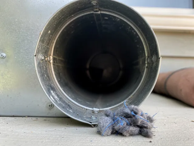 Charlotte Dryer Vent Cleaning technician using specialized equipment to clear severe dryer vent blockage in Charlotte